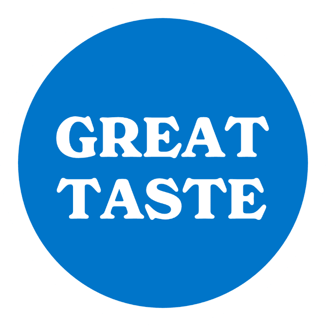 A circular blue logo with a white border and the words "GREAT TASTE" written in bold, white capital letters in the center, reminiscent of Tranquini's mixed berries flavor.